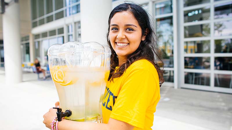 female student holding a lemonade container
